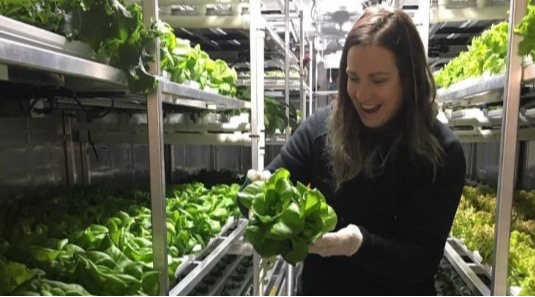 Woman holding head of lettuce grown in Churchill, Manitoba
